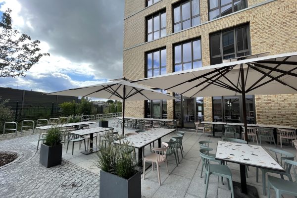 Restaurantterasse in Berlin Friedrichshain I Sonnenschirme Caravita Big Ben Auf dem Bild sehen Sie einen Außenbereich mit zwei Groß Sonnenschirmen von Caravita Big Ben, für das Restaurant Koko & Lores in Berlin Friedrichshain.